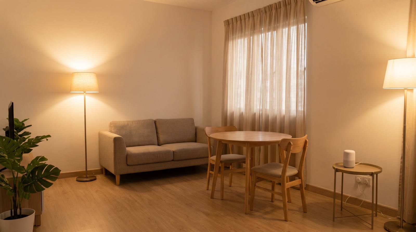 Ruang tamu apartmen sewa di Malaysia dengan hab kecil di atas rak, penderia tanpa wayar pada pintu dan tingkap, dan tiada kerosakan dinding yang kelihatan