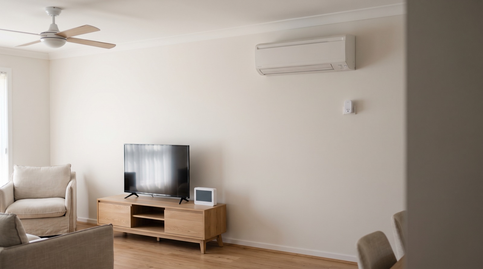 Sudut utiliti rumah Malaysia dengan aircond tingkap, mesin basuh dan televisyen dalam cahaya siang yang terang